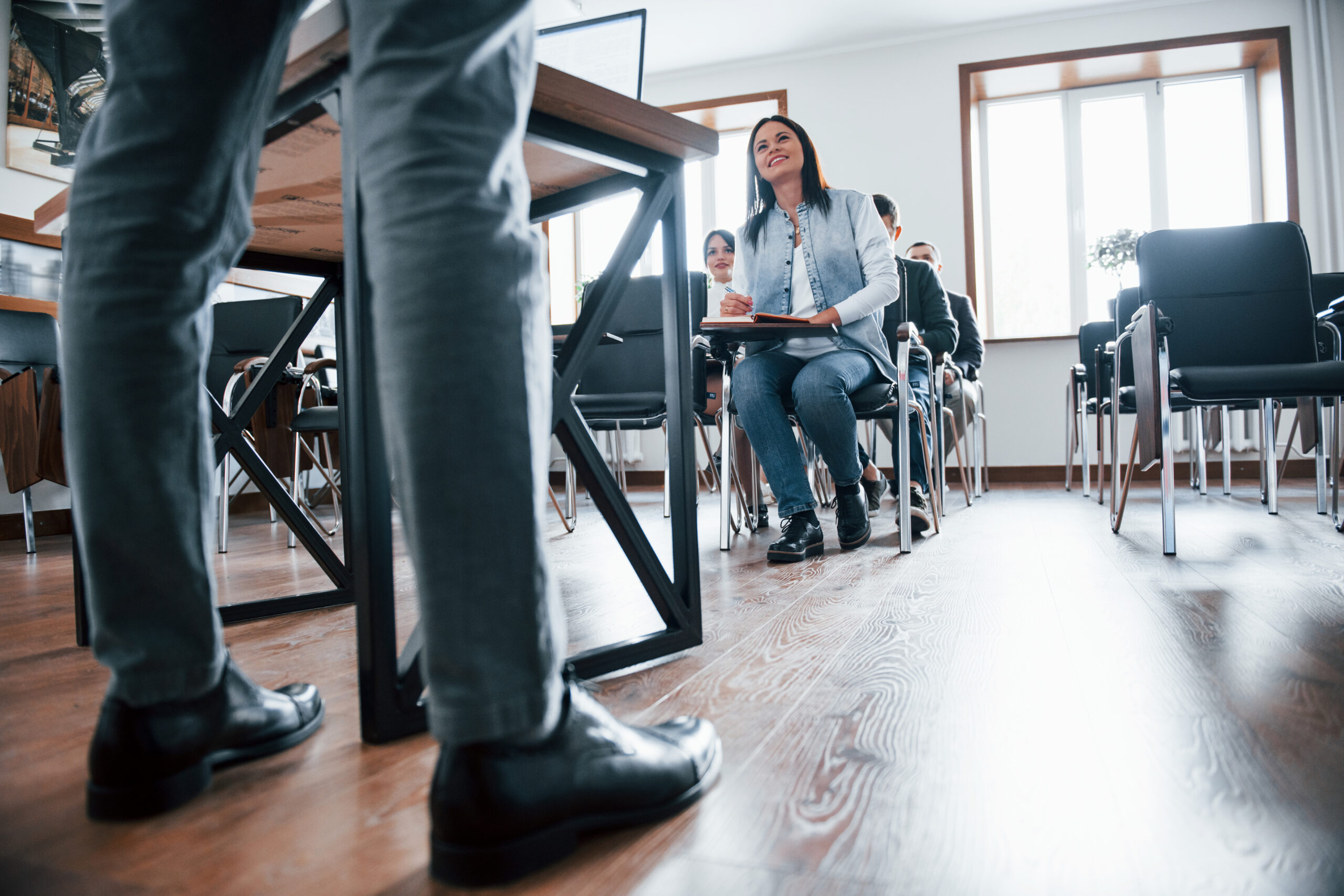 Active conversation with crowd. Group of people at business conference in modern classroom at daytime.